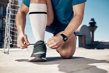 Image showing Soccer, man and tie shoe for training, exercise and workout on concrete court before sports game and match. Football, fitness and athlete prepare shoes for cardio sport performance on outdoor court