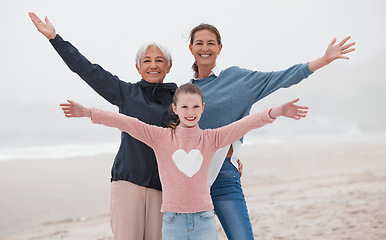 Image showing Family, love and beach with a girl, mother and grandmother on the sand by the sea or ocean during a vacation together. Travel, love and nature with a senior woman, daughter and grandchild on holiday