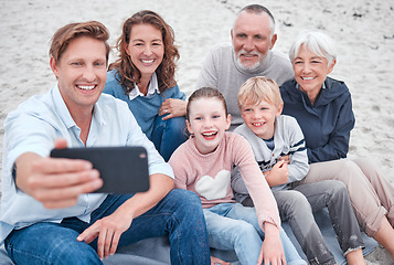 Image showing Family, generations and selfie, together and happy on outdoor adventure at beach, smartphone and technology. Parents, grandparents and children smile, spending quality time and bonding at the coast.