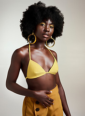 Image showing Yellow fashion, makeup and beauty with a black woman model in studio on a gray background for a contemporary photo shoot. Cosmetics, accessories and style with an edgy female posing in trendy clothes