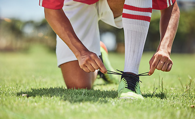 Image showing Hands, shoes and soccer player at a soccer field, tie lace and prepare for training, sports and fitness game. Football, hand and football player getting ready for workout, exercise and sport practice