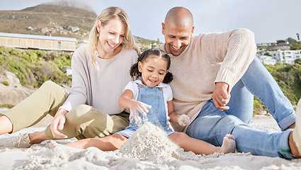 Image showing Happy, beach and family with castle in sand for summer, freedom and travel vacation together. Love, smile and relax with mother and father playing with girl for holiday, lifestyle and building