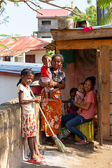 Image showing Two young mothers with their children in front of their house.