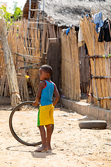 Image showing Young boy standing on a dirt road holding a tire Miandrivazo, Madagascar