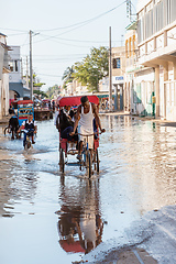 Image showing Traditional rickshaw bicycle with Malagasy people on the street of Toliara, one of the ways to earn money. Everyday life on the street of Madagascar.