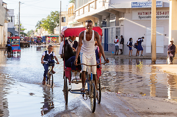 Image showing Traditional rickshaw bicycle with Malagasy people on the street of Toliara, one of the ways to earn money. Everyday life on the street of Madagascar.