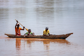 Image showing Malagasy family in traditional wooden boat ride on the Mania River in Madagascar.