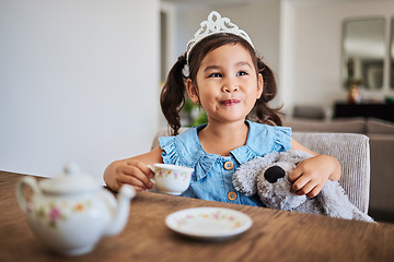 Image showing Happiness, tea party and child in her home, playing, having fun with tea set and wearing a crown. Creativity, imagination and young Asian girl enjoying toys, teddy bear and toy kitchen utensils