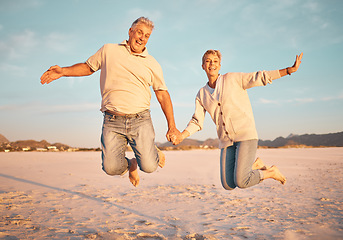 Image showing Couple, beach and active seniors hold hands while jumping in sand, happy and excited at sunset. Love, family and freedom with mature man and woman jump in celebration of retirement, travel and energy