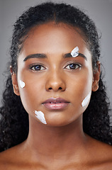 Image showing Beauty, face and skincare cream with black woman in a studio for wellness, grooming and hygiene against grey background. Portrait, model and sunscreen product for cosmetic, dermatology and facial