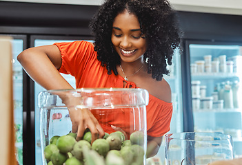 Image showing Black woman, grocery store and shopping, hand in jar and fruit to buy, customer and fresh product at local supermarket. Food, retail and sale, shop organic and young African American female in store.