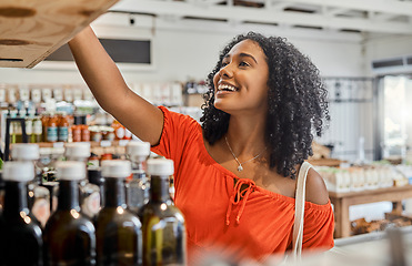 Image showing Supermarket, shelf and shopping customer woman retail store for eco friendly product, olive oil or groceries choice. Happy woman in small business store marketplace with choice or food sale discount