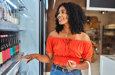Image showing Happy, grocery shopping and woman in a supermarket with drinks at a retail store in Sao Paulo. Happiness, smile and girl from Brazil buying a beverage on a shelf in a food shop while on vacation.