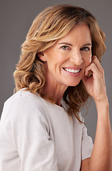 Image showing Face, portrait and beauty with a senior woman in studio on a gray background to promote antiaging. Skincare, product and retirement with a mature female pensioner posing for wellness or health