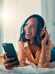 Image showing Music, smartphone and relax black woman on bed streaming radio song, wellness podcast or sound. Headphones, digital mobile and happy young girl listening to rock, disco or rap audio in home bedroom