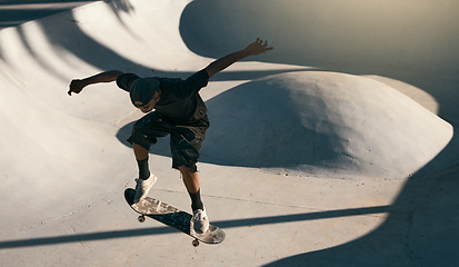 Image showing Man, skater and skateboard at park in air, trick or jump on ramp with speed, technique and sport. Skateboarder, action and concrete at event, game or contest with shoes in summer, sunshine or outdoor
