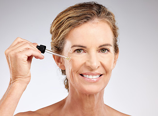 Image showing Elderly, woman and skincare with serum, cosmetic and beauty against grey, studio or background. Model, smile and skin for makeup, cosmetics and senior with happiness, anti-aging and care for health