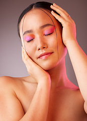 Image showing Eyeshadow, asian and beauty woman with hands on face pose with pink and orange cosmetics. Funky, trendy and colorful fashion makeup model for Gen Z cosmetic style on grey studio background.