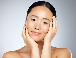 Image showing Skincare, beauty and woman with facial wellness against a grey mockup studio background. Face portrait of a young, Asian and happy model with luxury cosmetics from dermatology and mock up space