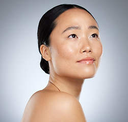 Image showing Beauty, asian and woman skincare with natural face thinking or contemplating with beautiful glow. Cosmetic hydration advertising for healthy skin with thoughtful model girl on grey studio mockup.