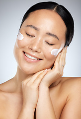 Image showing Facial cream, skincare and happy woman with sunscreen product, face moisturizer or beauty cosmetics in studio. Headshot portrait of a healthy Asian model with a big smile after self care wellness