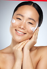 Image showing Skincare, beauty and Asian woman with cream on face, smiling in studio on white background. Wellness, skincare products and portrait of happy girl with sunscreen, lotion and beauty product for facial