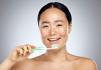 Image showing Brushing teeth, asian woman beauty and dental wellness, health and cleaning cosmetics on studio background. Happy young Japanese model face portrait, toothpaste on toothbrush and healthy mouth breath