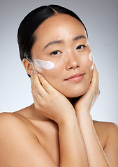 Image showing Beauty, asian skincare and woman using face cream or dermatology product for healthy and clean skin. Studio portrait of happy girl model feeling luxury facial or daily cosmetics routine results