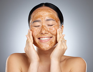 Image showing Facial, product and woman skincare face mask cosmetics cleaning smooth and soft skin in Asian studio. Relaxed, smile and happy beauty model peeling a healthy natural grooming scrub or mud in Seoul