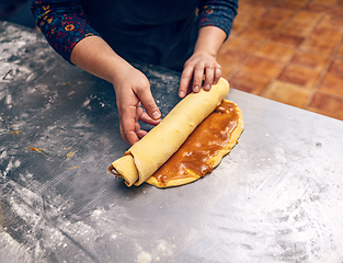 Image showing Rolling stuffed dough for make babka.