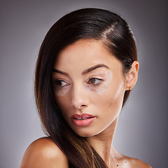 Image showing Beauty, face and vitiligo with a model woman in studio on a gray background for natural hair care. Wellness, luxury and cosmetics with a young female posing for dermatology, wellness or pigmentation