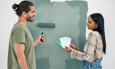 Image showing Painting, wall and couple with color choice for home renovation, green room design and house project teamwork. Happy woman with partner with brush and green eco friendly paint decision or development