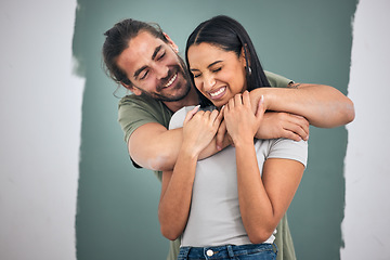 Image showing Happy, couple and hug for love, home improvement and smile against a painted wall background. Man and woman smiling for creative interior design in relationship, painting or house renovation together