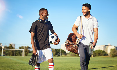 Image showing Soccer, training and friends walking on field after practice, match and football game. Diversity, fitness and men happy after exercise, workout and playing sports together carrying gear, ball and bag