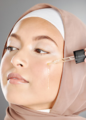 Image showing Muslim woman beauty, facial serum or essential oil, aesthetic makeup or glowing skincare on studio background. Islamic hijab girl, liquid cosmetic product or hyaluronic acid on clean face dermatology