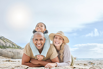 Image showing Family, diversity and lying at beach, smile or portrait to relax, together and sun by sea for happiness. Woman, black man and child on vacation, holiday or travel to ocean, family and happy in summer