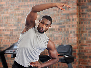 Image showing Exercise, black man and stretching for workout, fitness and wellness being healthy, in sportswear and in gym with focus face. African American trainer, athlete or male for health, cardio and training