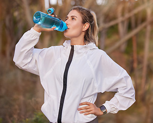 Image showing Exercise, woman runner and on break drinking water doing workout, rest and sportswear being healthy, fitness or wellness. Female athlete, runner girl or training for thirsty, health or cardio outdoor