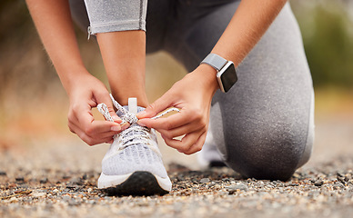 Image showing Shoes, fitness and exercise with a sports woman tying her laces before training, running or a workout. Hands, health and cardio with a female runner or athlete getting ready for an endurance run
