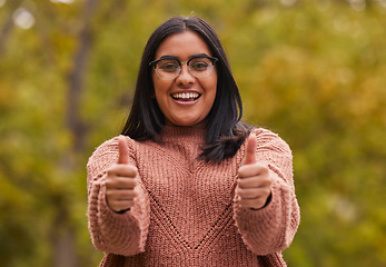 Image showing Woman, thumbs up and happy success winner proud hand gesture in nature on travel vacation or summer holiday break. Yes, well done, thank you and motivation achievement support smile or relax outdoors