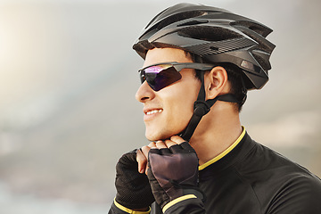 Image showing Fitness, sports and cyclist checking his helmet before cycling, training, workout and cardio ride in nature. Health, biking and athletic man getting ready for cycle, happy, smile and relaxed training