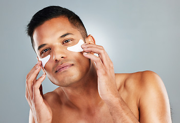 Image showing Model, skincare and eye mask for man in portrait for health, wellness and cosmetics with grey backdrop. Face, cosmetic and facial for beauty, self love and self care with studio background for care