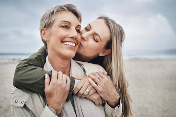 Image showing Kiss, mother and daughter at beach smile, hug and kiss with smile together in Australia. Happy face of young woman with a senior mom in the sea or ocean together with love and to relax in happiness