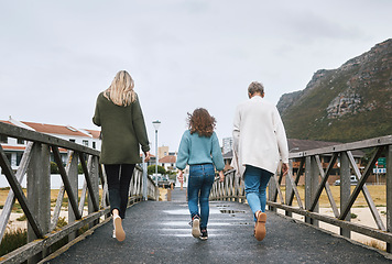 Image showing Family, walking and bridge in nature by mountain together on holiday, vacation and relax. Group, people and walk for bonding, time and love with kid, mother and grandmother on travel to Norway