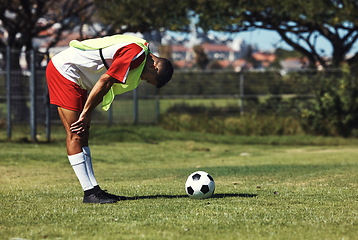 Image showing Man, tired and soccer ball on field in training, warmup or workout outdoor in summer. Exercise, soccer player and rest by football on grass in sunshine for sport, health or performance in development