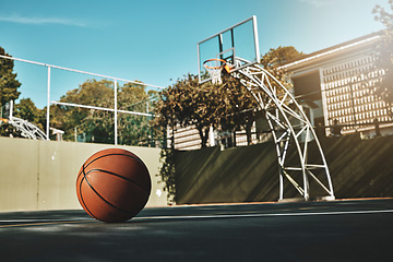 Image showing Basketball, outdoor and court with ball on floor for athletic competition or recreation low angle. Exercise, cardio and empty basketball court ground with basket for sports, match or workout.