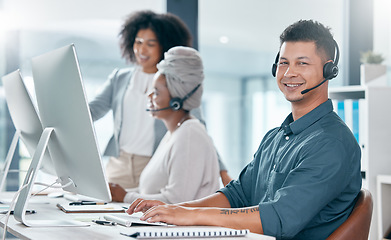 Image showing Call center, customer service and telemarketing consultant man and diversity team working in crm office. Contact us, teamwork and support male employee typing on pc and wearing headset for support