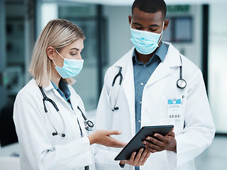 Image showing Healthcare, covid and doctors checking tablet for medical data, patient chart or insurance documents in hospital lobby. Face mask, man and woman working in medicine consulting internet before surgery