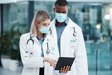 Image showing Covid, planning and doctors with a tablet for healthcare, medical partnership and research on the internet at a hospital. Team of workers in medicine reading information on technology with face mask