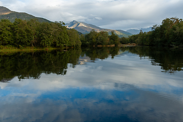 Image showing A body of water with trees and mountains in the background